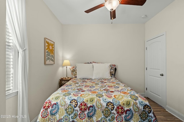 bedroom with wood finished floors, a ceiling fan, and baseboards