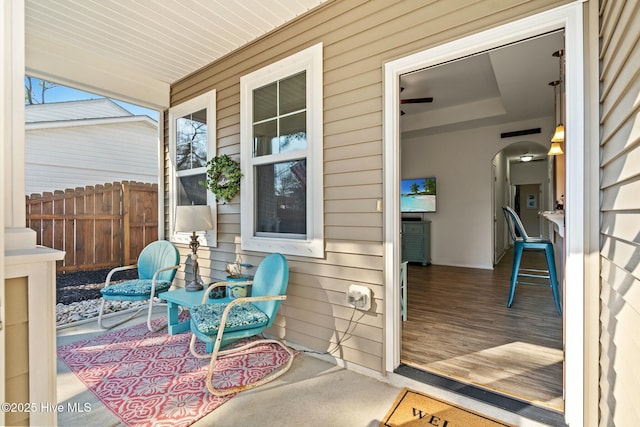 view of patio featuring fence and a porch