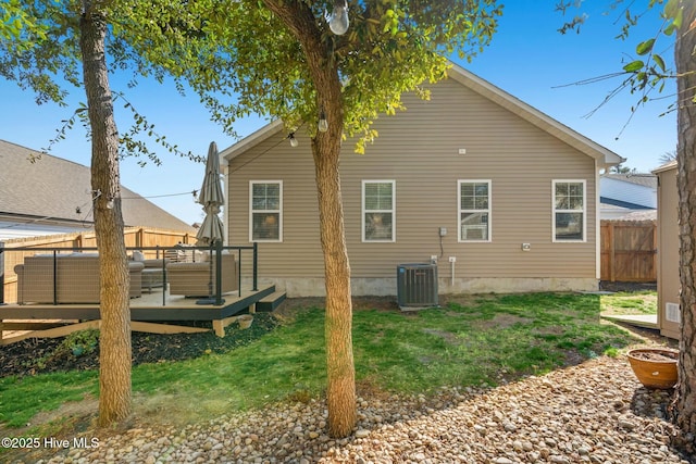 back of property with central AC unit, a lawn, fence, and a wooden deck