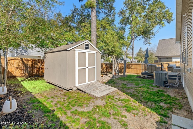 view of shed with cooling unit and a fenced backyard