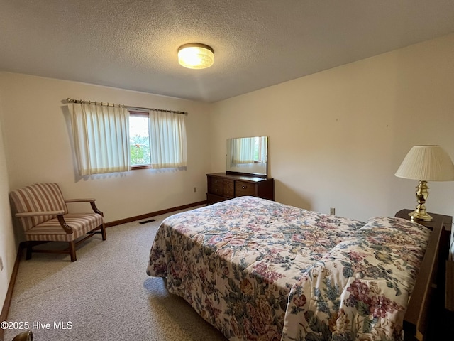 bedroom with light colored carpet and a textured ceiling