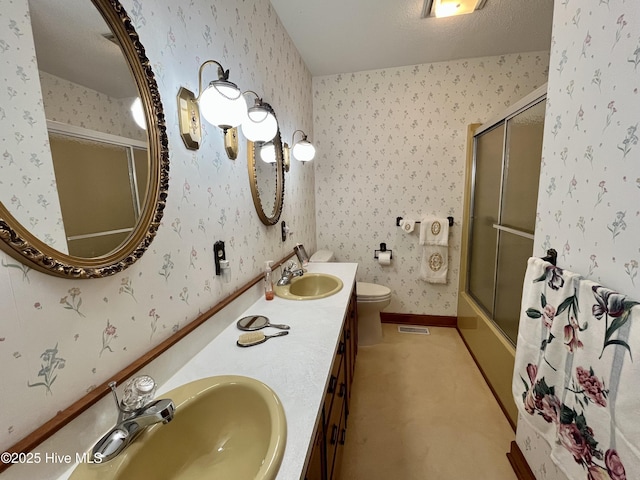 full bathroom with vanity, a textured ceiling, shower / bath combination with glass door, and toilet