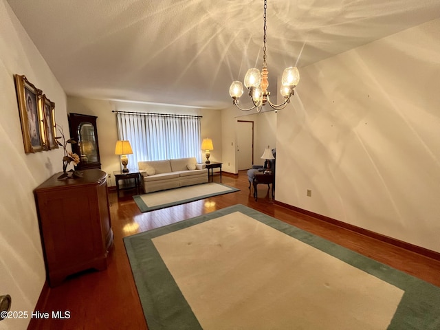 living room with dark hardwood / wood-style floors and a notable chandelier