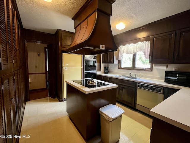 kitchen featuring a kitchen island, sink, island exhaust hood, black appliances, and a textured ceiling