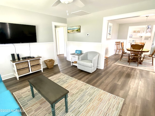 living room featuring ceiling fan, built in features, and dark hardwood / wood-style flooring