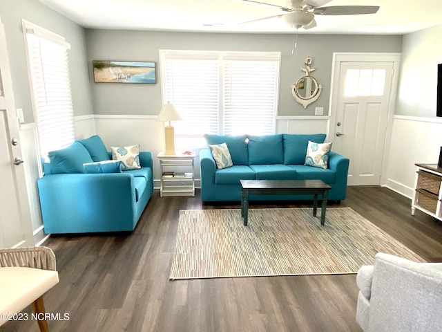 living room with dark wood-type flooring, ceiling fan, and a wealth of natural light