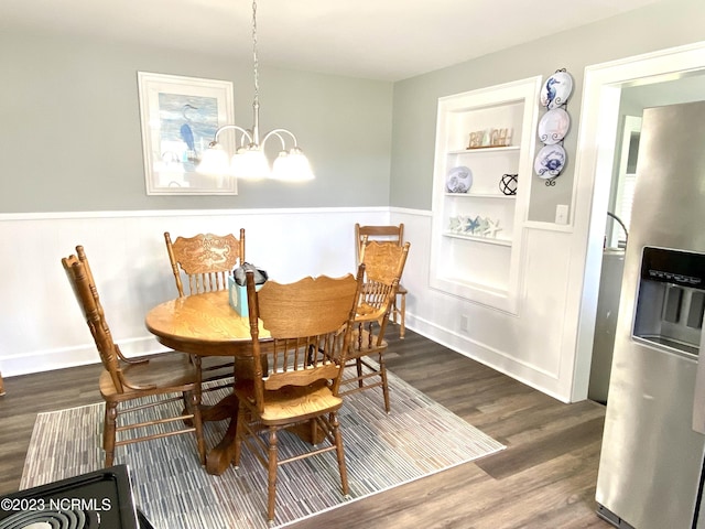 dining space with dark wood-type flooring, built in features, and a chandelier