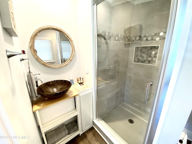 bathroom featuring a tile shower, vanity, and hardwood / wood-style flooring