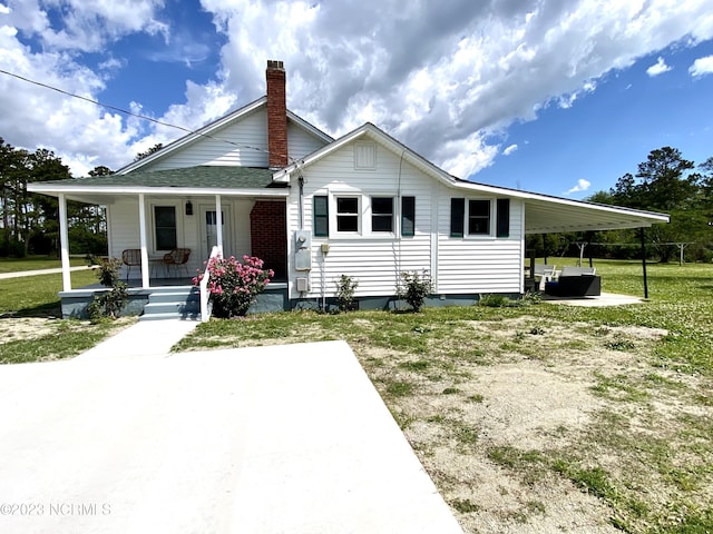 rear view of property with a yard and covered porch