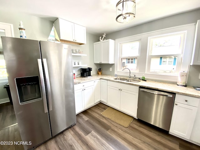 kitchen with sink, stainless steel appliances, dark hardwood / wood-style floors, light stone countertops, and white cabinets