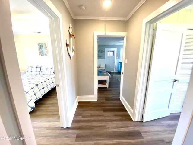 corridor with dark wood-type flooring and crown molding