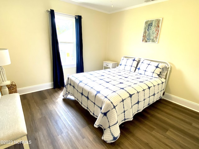 bedroom featuring ornamental molding and dark hardwood / wood-style flooring