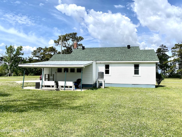 rear view of property featuring a patio, outdoor lounge area, and a lawn