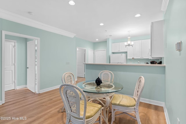 dining space featuring crown molding, a notable chandelier, and light hardwood / wood-style flooring