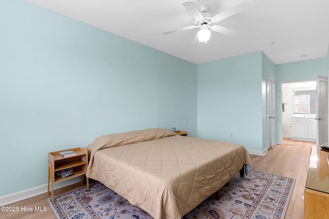 bedroom featuring light hardwood / wood-style flooring, ceiling fan, and ensuite bathroom