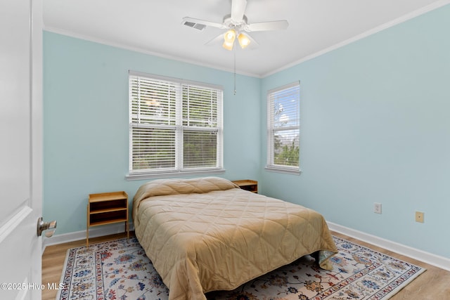 bedroom featuring crown molding, wood-type flooring, and ceiling fan