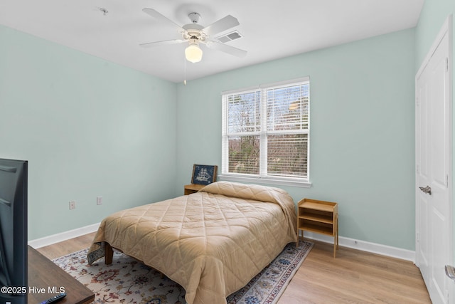 bedroom featuring ceiling fan, light wood-type flooring, and a closet