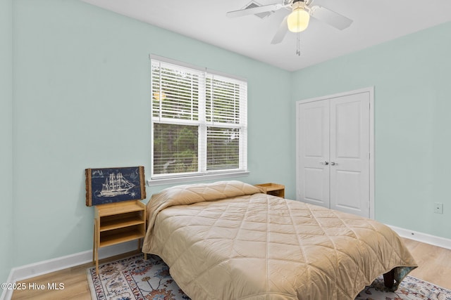 bedroom with hardwood / wood-style flooring, a closet, and ceiling fan