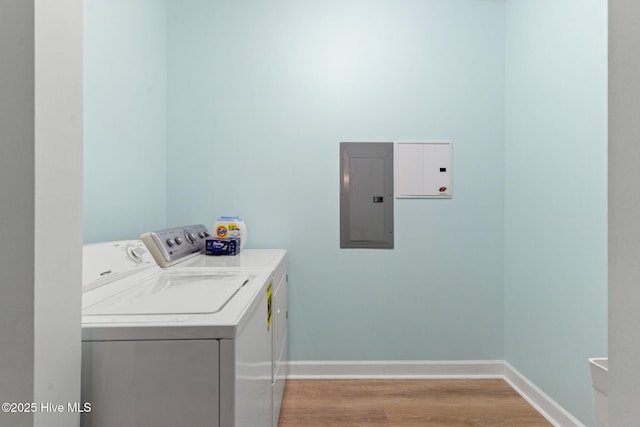 laundry area with washer and dryer, electric panel, and light wood-type flooring