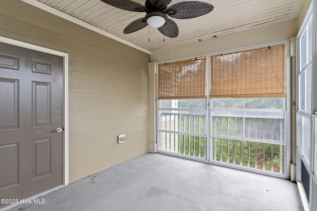 unfurnished sunroom featuring wood ceiling and ceiling fan