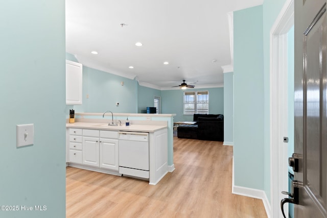 kitchen featuring sink, light wood-type flooring, ornamental molding, white dishwasher, and white cabinets