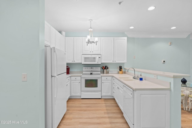 kitchen with white cabinetry, pendant lighting, white appliances, and kitchen peninsula