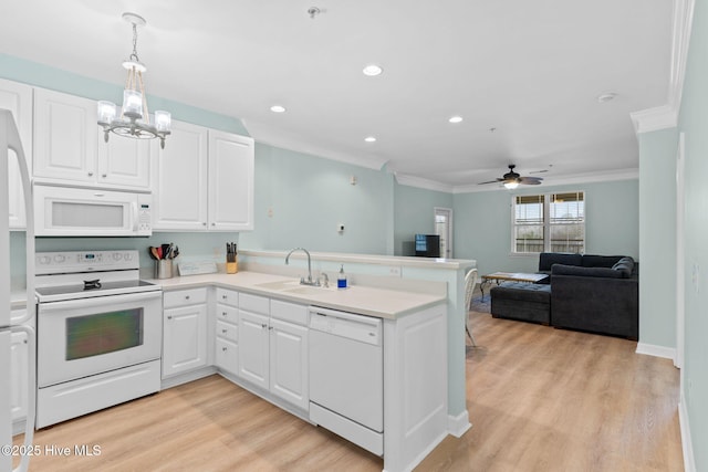 kitchen featuring white appliances, decorative light fixtures, kitchen peninsula, and white cabinets