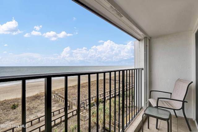 balcony with a water view and a view of the beach