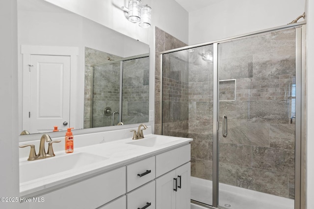 full bath with double vanity, a sink, and a shower stall