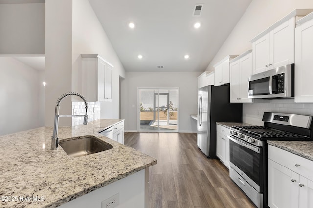 kitchen featuring a sink, decorative backsplash, appliances with stainless steel finishes, and white cabinets