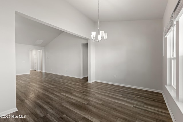 spare room featuring a notable chandelier, dark wood-style floors, and baseboards