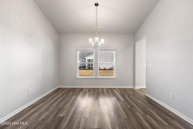 unfurnished dining area with visible vents, a notable chandelier, baseboards, and dark wood-style flooring