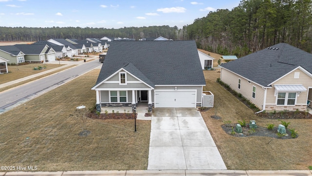 traditional-style home with driveway, roof with shingles, a porch, a garage, and stone siding