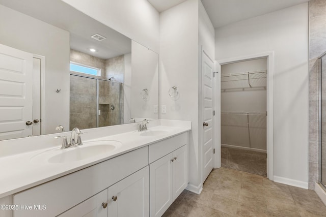 full bath with double vanity, visible vents, a stall shower, and a sink