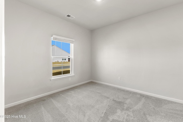 empty room featuring visible vents, baseboards, and carpet flooring