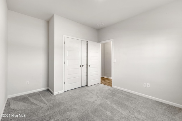 unfurnished bedroom featuring a closet, baseboards, and carpet floors