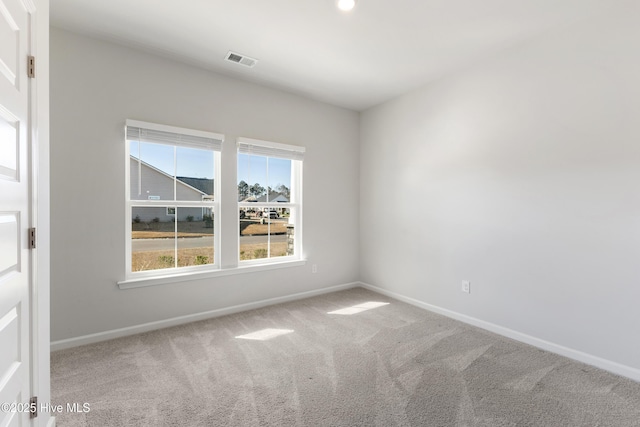 carpeted spare room featuring visible vents and baseboards