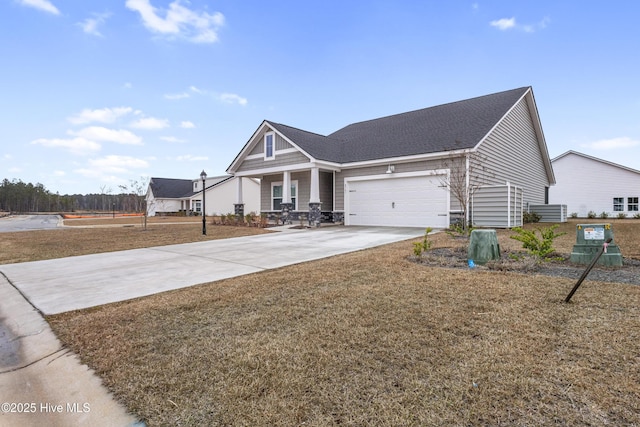 view of front facade with concrete driveway, an attached garage, a front lawn, and a shingled roof