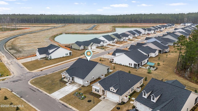 bird's eye view featuring a residential view, a wooded view, and a water view