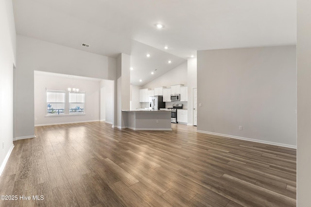 unfurnished living room with a notable chandelier, visible vents, dark wood-style flooring, and high vaulted ceiling