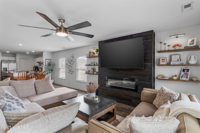 living room featuring hardwood / wood-style floors, a fireplace, and ceiling fan