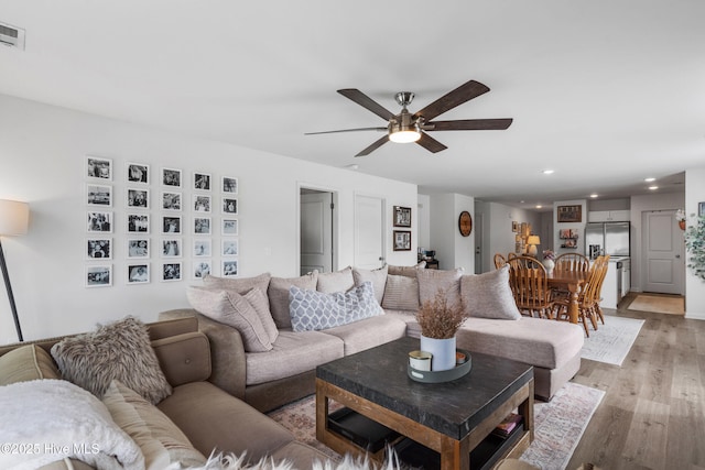 living room featuring ceiling fan and light hardwood / wood-style flooring