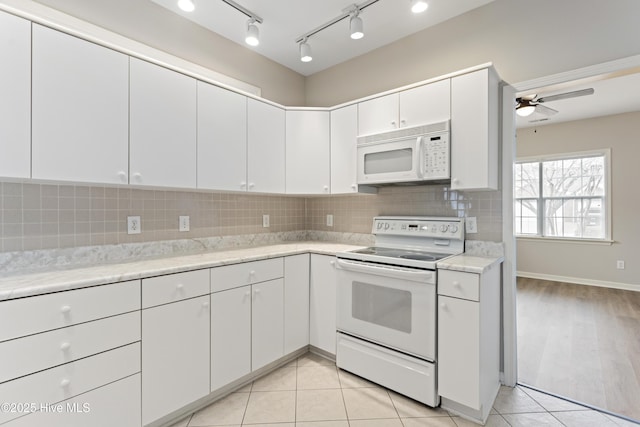 kitchen with white appliances, backsplash, ceiling fan, white cabinetry, and light tile patterned floors