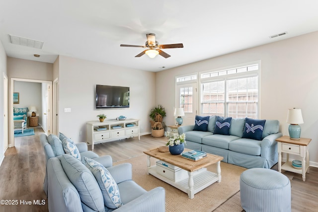 living room featuring wood finished floors, ceiling fan, and baseboards