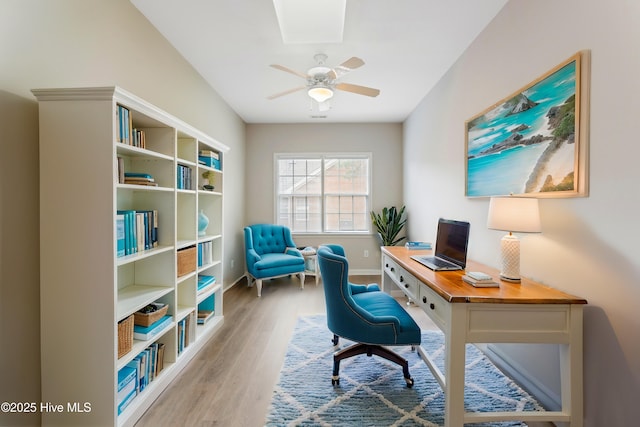 office area with wood finished floors, a ceiling fan, and baseboards