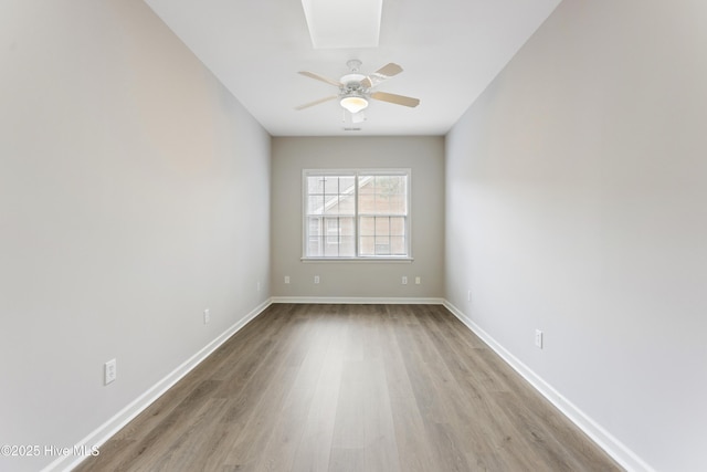 spare room featuring wood finished floors, ceiling fan, and baseboards