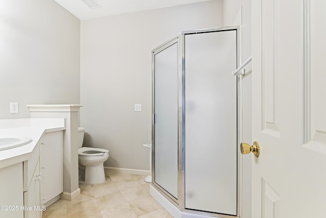 bathroom with a shower stall, vanity, toilet, and baseboards