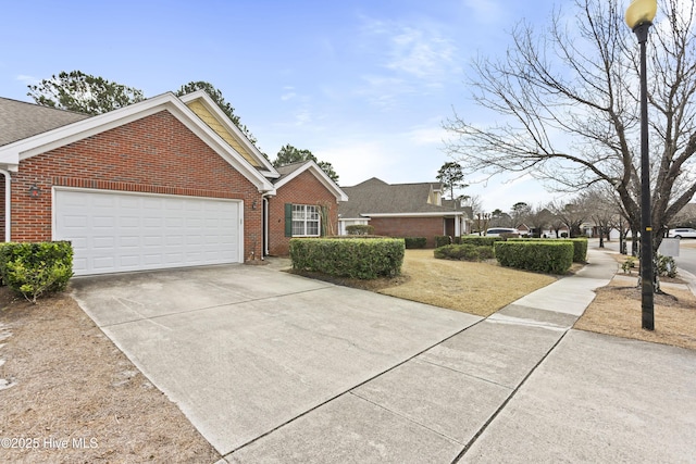 view of front of home with an attached garage, concrete driveway, and brick siding