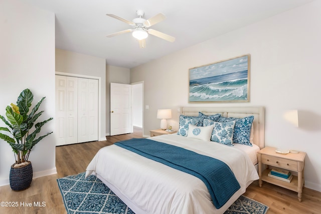 bedroom featuring a closet, wood finished floors, baseboards, and a ceiling fan