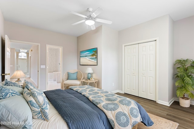 bedroom with wood finished floors, a closet, baseboards, ceiling fan, and ensuite bath